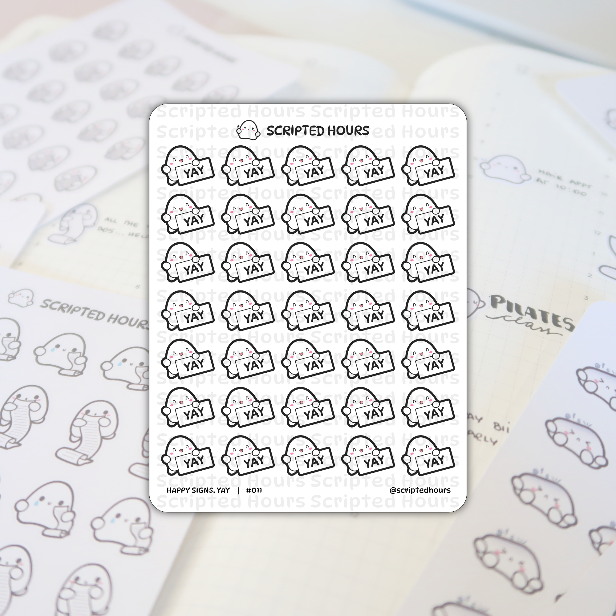 Scripted Hours die-cut vinyl planner stickers featuring numerous smiling white ghost-like characters with pink cheeks holding bold black YAY signs, positioned on an open journal displaying 'PILATES class' notes and blurred companion sheets of crying and list-holding stickers