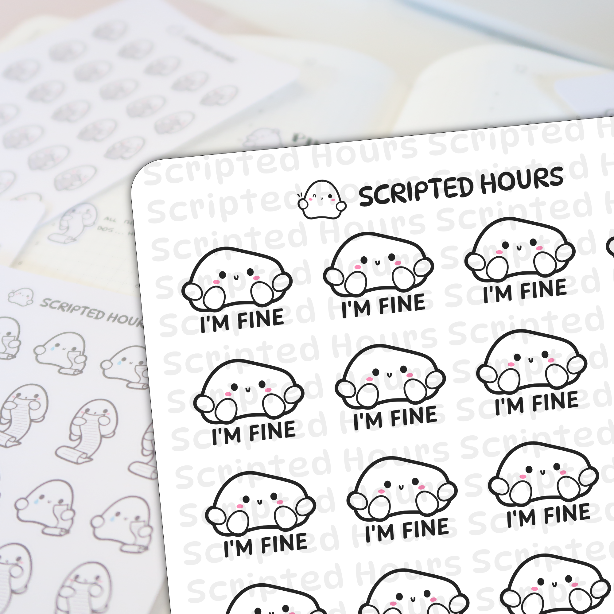 Die-cut vinyl stickers by Scripted Hours depict a sheet of white blob-shaped characters with minimalist black eyes, small 'v' mouths, pink blush cheeks, and "I'M FINE" text below each, with a blurred second sheet of ghost-like scroll-holding characters in the background