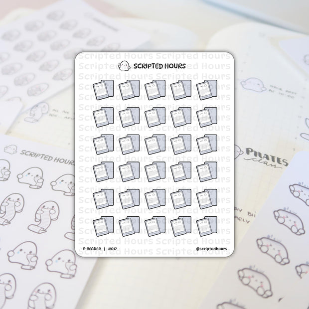 Scripted Hours E-READER #017 sticker sheet with multiple rows of grey e-reader icons featuring the brand logo, layered over a white grid-lined planner with handwritten 'PILATES class' text and a partially visible second sticker sheet of cute ghost characters holding long scrolls