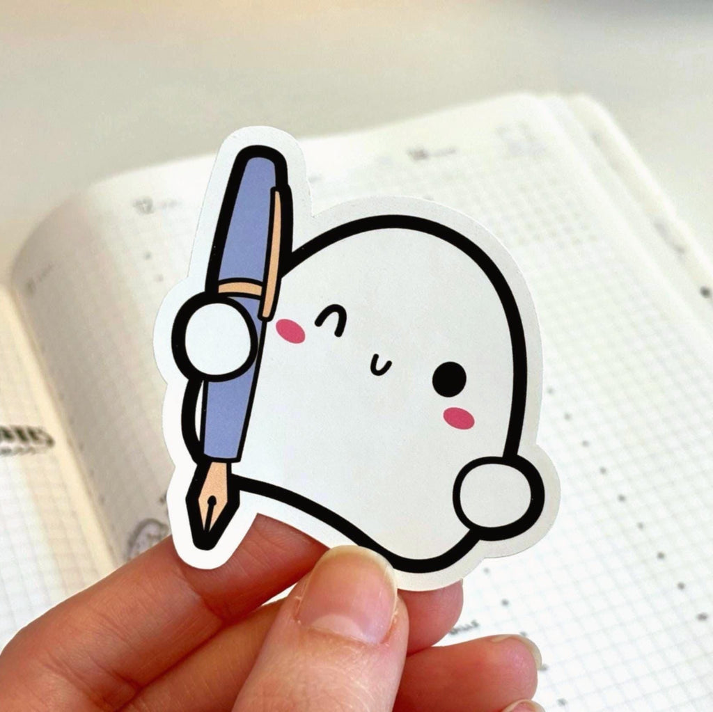 Cute cartoon character sticker holding a pencil on an open notebook