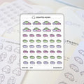 Scripted Hours sticker sheet featuring pastel green and lavender washi tape rolls, rows of cute ghost characters holding long lists, and the brand's ghost with a lightbulb logo, laid on a desk beside a planner with "Pilates class" written