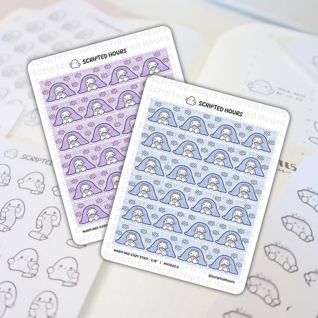Sticker illustration by Scripted Hours featuring two 'Warm and Cozy' sticker sheets with white ghost characters holding mugs under purple blankets with pink flowers and blue blankets with blue flowers, displayed on a planner page next to outline ghost stickers