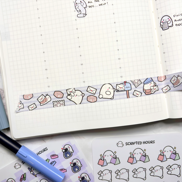 A flat lay of a white grid planner page adorned with pastel blue striped washi tape featuring cute ghost characters mailboxes and envelopes surrounded by matching ghost sticker sheets depicting shopping and fitness