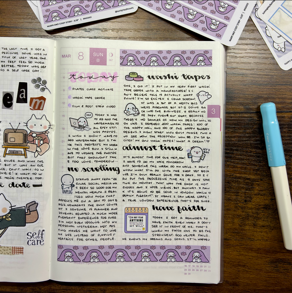Open planner with stickers and a pen on a wooden surface