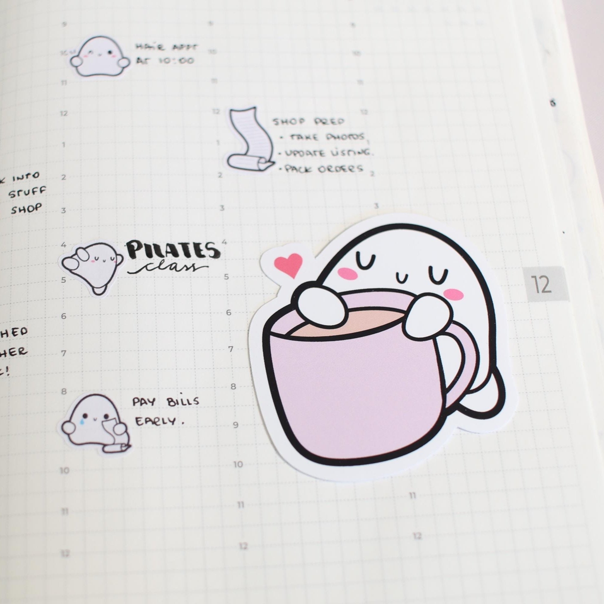 Illustrated ghost character with a cup of coffee in a notebook